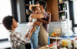 © NDABCREATIVITY - Happy family preparing healthy food in kitchen together