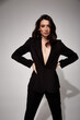 © indiraswork - Fashion beauty model dark hair style beautiful sexy pretty woman perfect skinny body shape cosmetic makeup face wear clothes black trend suit silk pants jacket accessory shoes studio background.