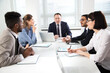 © chagin - Group of multi-ethnic business people sitting around the office desk and discussing the project