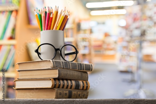 Obraz Dibond Stack of vintage books, eyeglasses and pencils, education and learning