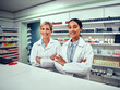 © StratfordProductions - Happy young female pharmacist with senior colleague with folded hands smiling at the camera