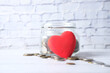 © Towfiqu Barbhuiya  - Red heart and coins in a jar on blue background