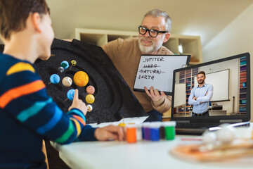 kid presenting his science home project - the planets of our solar system. father helping his son wi