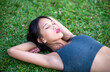 © jovannig - Beautiful asian girl lying down on the grass relaxing in the city park