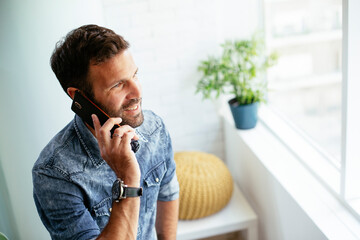 Wall Mural - Businessman in office using the phone. Young businessman talking to the phone