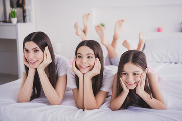 Canvas Print - Photo of sweet adorable three sisters sleepwear lying bed having rest smiling arms cheekbones inside indoors home room