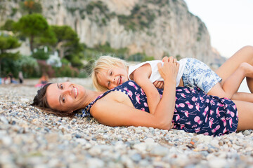 Canvas Print - Loving mother and son, blond toddler boy, hugging at the beach, enjoying time