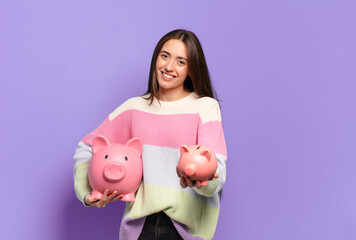 Poster - young pretty woman with a piggy bank