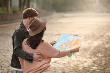 Poster - Couple of travelers with map on city street