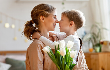 Wall Mural - happy woman and boy with flowers touching noses