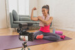 © SB Arts Media - Woman personal coach trainer recording online fitness class on camera at home