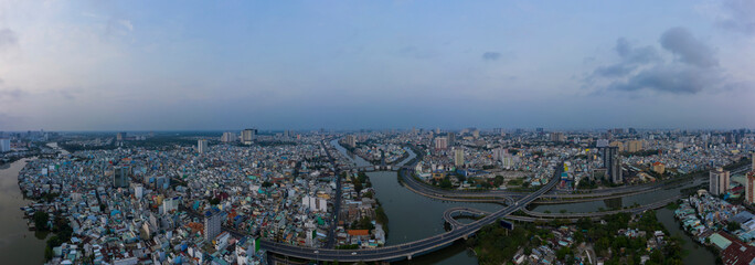 Wall Mural - Early morning drone panorama before sunrise. The big sprawling city is waking up with traffic, bridges, main roads, off ramps and canal system of Ho Chi Minh City, Early morning drone panorama Vietnam