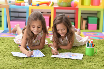 Canvas Print - Two cute little girls drawing with pencils