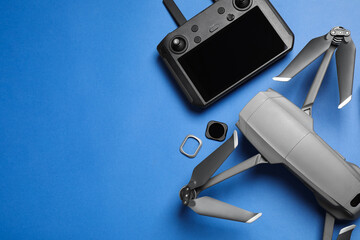 Wall Mural - modern drone with camera and video production equipment on blue background, flat lay. space for text