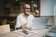 © BullRun - Bewildered senior businessman looking in disbelief while working in cafe