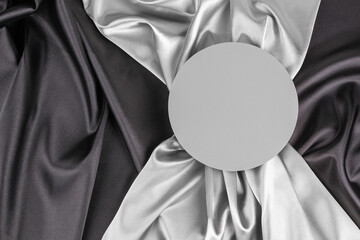 Wall Mural - Circle platform podium on elegant black and light gray color background with drapery and wavy folds of silk satin material. Gray mock up background for cosmetic product presentation. Top view