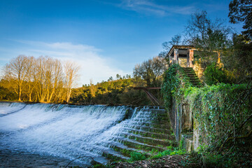 River water dam with waterfall and silky water. Water dam in Nabao river, Tomar, Portugal.
