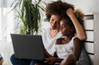 © lordn - African American family. Mother and daughter using laptop computer at home or learning