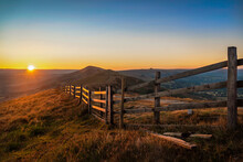 Stunning Mam Tor Peak District Early Morning Dawn Sunrise With Long Fence And Beautiful Golden Hour Orange Light Sun On The Horizon Of Hope Valley Castleton Countryside Landscape