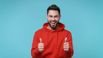 Wall Mural - Back rear view of funny cheerful bearded young man 20s in casual red streetwear hoodie isolated on blue background studio. People lifestyle concept. Turns around camera showing thumbs up like gesture