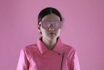 Wall Mural - portrait of a teenage girl in a pink leather jacket on a pink background