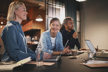 Wall Mural - Smiling Asian businesswoman working with colleagues in an office