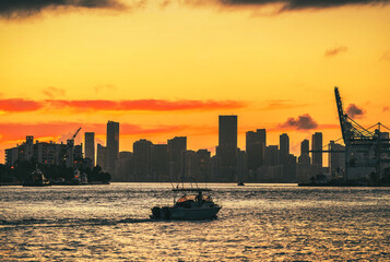 sunset sun horizon boat sea water view miami florida beautiful sky color yellow orange usa summer heat silhouette buildings 