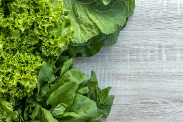 spinach, lettuce and cabbage leaves isolated on a wooden table with copy space in Brazil