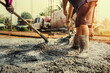 © lovelyday12 - pouring concrete with worker mix cement at construction site