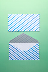 Wall Mural - Open striped envelope on green background.