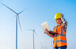 © geargodz - stressed female engineer having problem to working with laptop computer against wind turbine farm