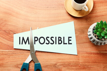 Poster - card with the text impossible, cutting the word im so it written possible. success and challenge concept.