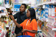 © Confidence - black people shopping in a supermarket
