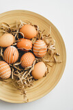 Fototapeta Kwiaty - Plate with nordic Easter eggs on white background. Flat lay, top view. Happy Easter concept.