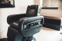 An Empty Black Leather Hydraulic Barbers Chair At A Salon Or Barbershop.
