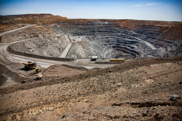 Wall Mural - Copper ore open-pit mining. Quarry dump truck and excavator on road down in quarry. Wide-angle panorama.