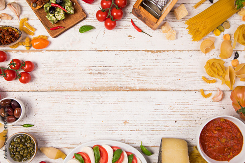 Various kind of italian food served on vintage wooden table. Top view, free space for text © Lukas Gojda