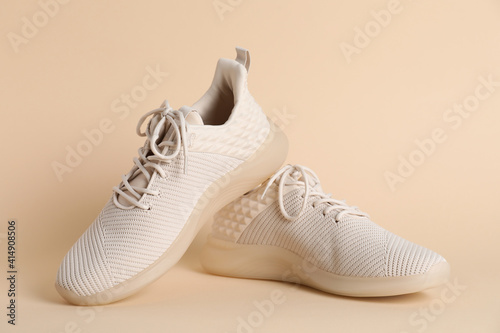 Obraz Dibond Pair of stylish sport shoes on beige background