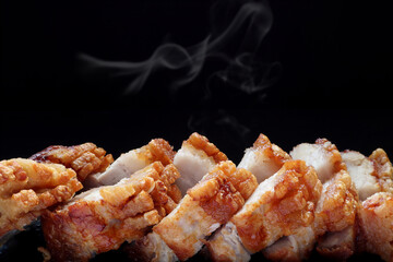 close up photo crispy roast pork belly on black table with background of black wall in the Chinese dim sum restaurant during tea time party (yam cha)