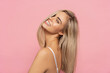 Leinwandbild Motiv Portrait of happy blonde woman with long straight hair isolated on pastel background