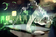 © peshkova - Double exposure of man's hands holding and using a digital device and forex graph drawing. Financial market concept.