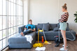© Avirut S. - Couple playing doing chores. Cheerful couple having fun while doing housework together. Happy young Caucasian couple playing and talking to each other while doing their housework cleaning their home.