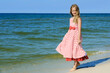 Beautiful girl in a dress walking on the beach