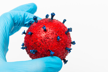 Wall Mural - Closeup shot of the Doctor's hand holding a red virus ball on a white background