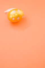 Wall Mural - Vertical shot of painted on Easter egg isolated on an orange background