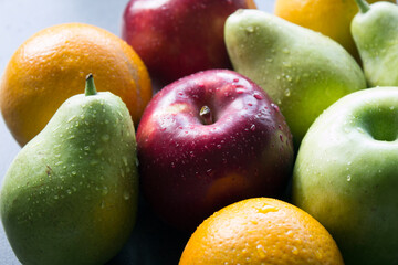 Organic fruits close up photo. Fresh juicy apples and pears on a table. Water drops on fa fruit skin. Healthy eating concept. 