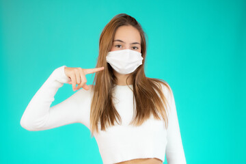 Young woman wearing surgical mask for corona virus over green background.