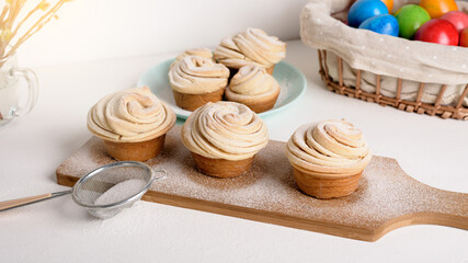 Wall Mural - cruffins easter spring pastries, a mixture of muffin and croissant on a light background, the composition Easter painted eggs willow and cake