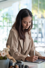 Wall Mural - Asian businesswoman working on a tablet at office.