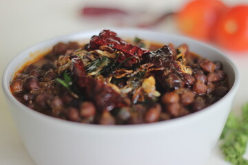 Wall Mural - Black chickpeas curry prepared by chickpeas cooked with onions, tomatoes and spices.